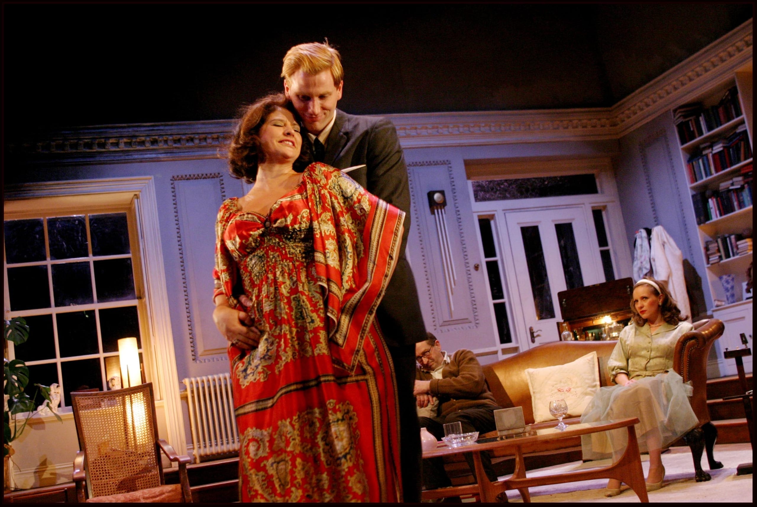 A woman in a floaty orange dress leaning on a man.