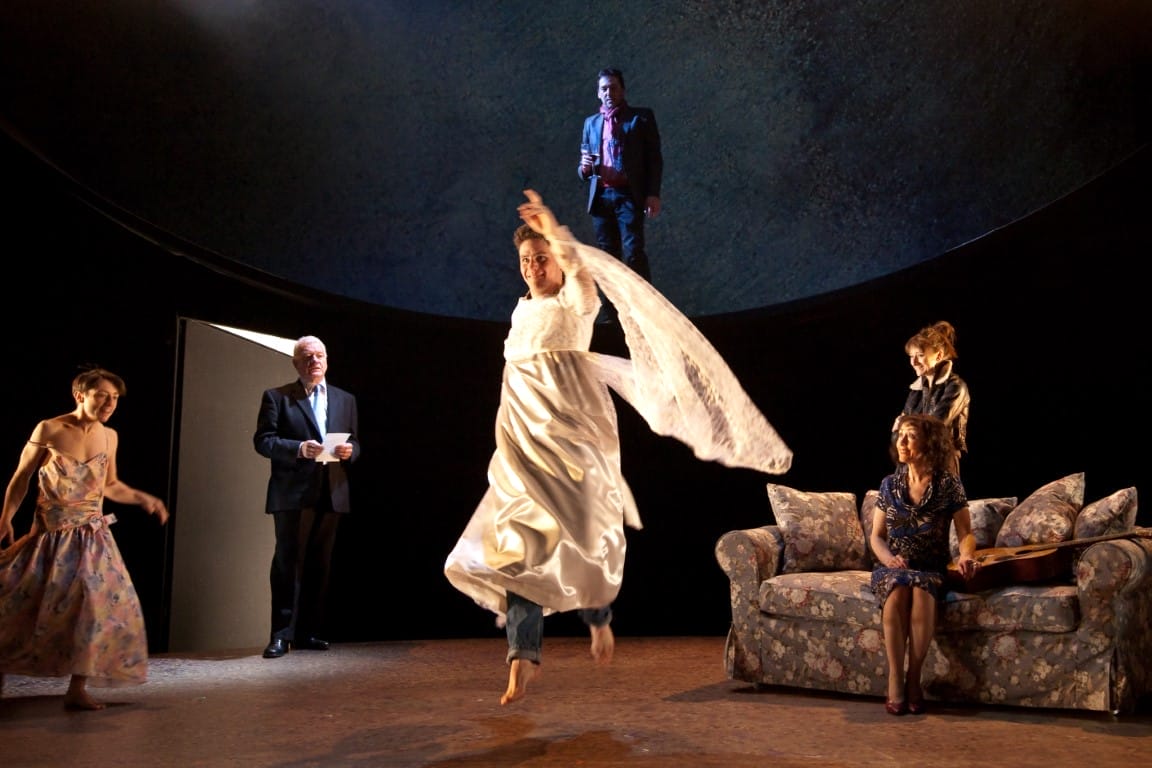 A man in a white dress jumping.