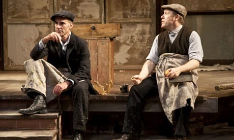 Two men sat in flat caps on the stairs.